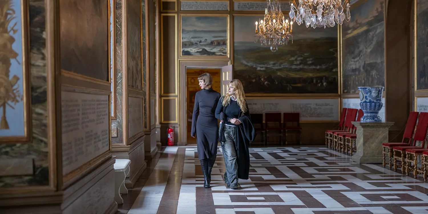 En guide visar en grupp besökare Drottningholms slott.